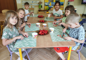 Zdjęcie przedstawia dzieci, które kroją truskawki do galaretki.