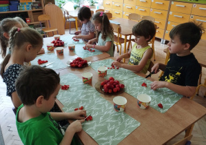 Zdjęcie przedstawia dzieci, które kroją truskawki do galaretki.