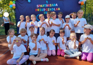 Zdjęcie przedstwia dzieci prezentujące medale otrzymane za udział w spartakiadzie.