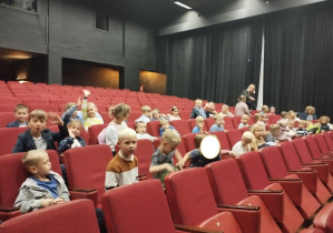 Zdjęcie przedstawia uczestników wycieczki siedzących na widowni.