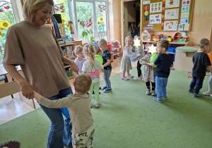 Zdjęcie przedstawia dzieci podczas zabawy muzyczno - ruchowej "Taniec z balonami".