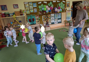 Zdjęcie przedstawia dzieci podczas zabawy muzyczno - ruchowej "Taniec z balonami".