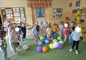 Zdjęcie przedstawia dzieci podczas zabaw z balonikami po odśpiewaniu piosenki.