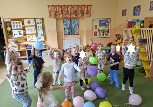 Zdjęcie przedstawia dzieci podczas zabaw z balonikami po odśpiewaniu piosenki.