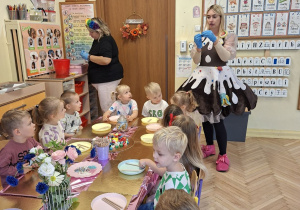 Zdjęcie przedstawia dzieci słuchające prowadzacej, która opowiadała o sposobie wykonania lizaków.