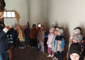 Zdjęcie przedstawia dzieci oraz prowadzącą opowiadającą o różnych rodzajach zbóż.