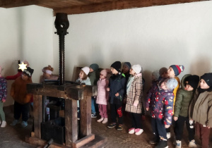 Zdjęcie przedstawia dzieci podczas zwiedzania starej kuźni.