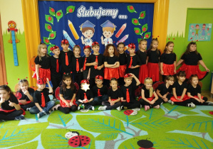 Zdjęcie przedstawia całą grupę w strojach "biedronek" na tle dekoracji.