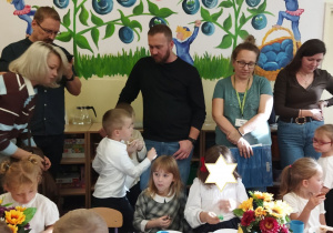 Na tym zdjęciu widać dzieci oraz rodziców podczas poczęstunku.