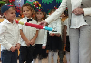 Na tym zdjęciu widać panią dyrektor, która pasuje dzieci z grupy III na przedszkolaka w grupie "Jagódek".