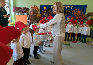 Zdjęcie przedstawia panią dyrektor, która pasuje dzzieci z grupy II na przedszkolaka.