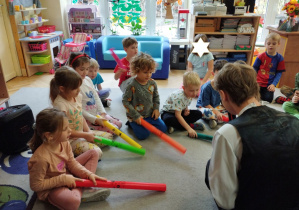 Zdjęcie przedstawia dzieci, które wydobywały dźwięk z plastykowych tub.