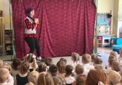 Na tym zdjęciu widać jedną ze scen teatrzyku oraz dzieci oglądające przedstawienie.