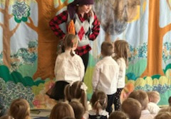 Na tym zdjęciu widać jedną ze scen teatrzyku oraz dzieci oglądające przedstawienie.