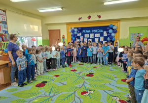 Na tym zdjęciu widać dzieci z grupy III i z grupy IV ubrane na niebiesko podczas uroczystości.