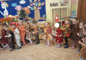 Zdjęcie przedstawia kilkoro dzieci z grupy II oraz z grupy I podczas zabawy w kole "Krasnoludek".