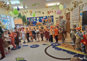 Zdjęcie przedstawia dzieci z grupy II podczas prezentacji jesiennych strojów.