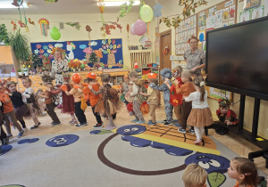 Zdjęcie przedstawia dzieci z grupy II podczas prezentacji jesiennych strojów.