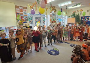 Zdjęcie przedstawia dzieci z grupy III podczas prezentacji jesiennych strojów.