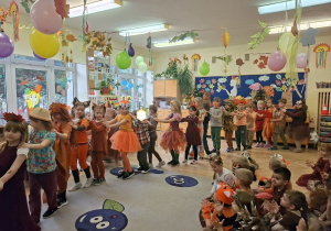 Zdjęcie przedstawia dzieci z grupy IV podczas prezentacji jesiennych strojów.