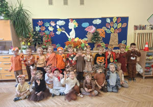 Zdjęcie przedstawia dzieci z grupy II na tle jesiennej dekoracji.