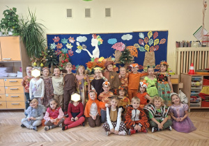 Zdjęcie przedstawia dzieci z grupy III na tle jesiennej dekoracji.