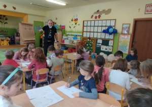 Na tym zdjęciu widać dzieci, które próbują swoich sił w przekształcaniu wzorów graficznych pod okiem ilustratora.