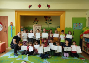 Zdjęcie przedstawia wszystkie dzieci w towarzystwie pana Artura Nowickiego, prezenetujące swoje prace.