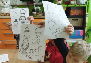 Zdjęcie przedstawia Adasia M. wraz z kolegami prezentujących swoje prace.