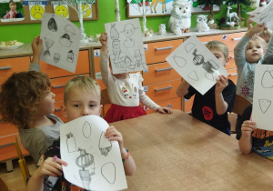 Zdjęcie przedstawia kilkoro dziweci prezentujących swoje prace.