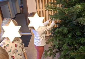 Na tym zdjęciu widać dwie dziewczynki oraz Henia D. z grupy I ubierających choinkę.