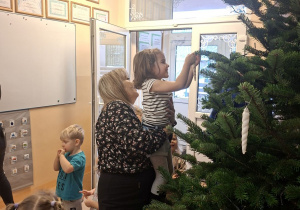 Na tym zdjęciu widać Emmę z grupy I wieszającą ozdobę na choince.