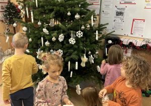 Zdjęcie przedstawia dzieci z grupy III ubierające choinkę.