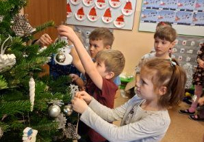 Zdjęcie przedstawia dzieci z grupy IV ubierające choinkę.
