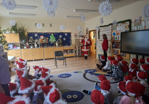 Na tym zdjęciu widać Mikołaja wchodzacego do sali z workiem prezentów.