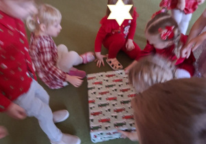 Na tym zdjęciu widać dzieci z grupy I rozpokowujące prezent, który Mikołaj zostawił w klasie maluszków.