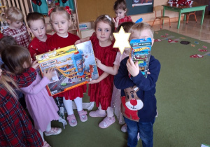 Na tym zdjęciu widać dzieci z grupy I prezentujące prezent od Mikołaja dla grupy maluszków.