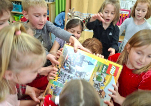 Na tym zdjęciu widać dzieci z grupy IV rozpokowujące prezent, który Mikołaj zostawił w klasie starszaków.