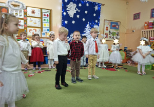 Zdjęcie przedstawia Mikołaja L., Adasia oraz Damiana recytujących wierszyk.