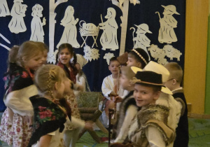 Zdjęcie przedstawia kilkoro dzieci podczas występu.