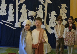 Zdjęcie przedstawia Alę R. i Stasia W. w roli Maryi i Józefa oraz czworo innych dzieci podczas występu.