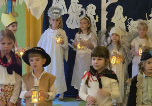 Na tym zdjęciu widać dzieci śpiewające piosenkę z latarenkami.