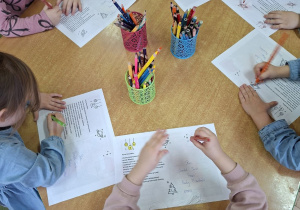 Zdjęcie przedstawia kolejne dzieci z grupy I kolorujące elementy na dedykowanej kartce do pana Premiera.