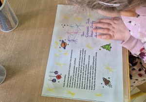 Na zdjęciu widać jedno z dzieci z grupy II kolorujące kartkę dla pana Premiera.