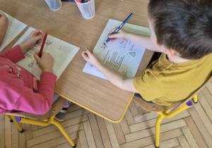 Zdjęcie przedstawia kilkoro dzieci z grupy II podczas wykonywania kartek dla pana Premiera.