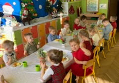 Na tym zdjęciu widać dzieci przy wspólnym, świątecznie udekorowanym stole.