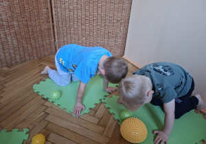 Na tym zdjęciu dwóch chłopców prezentuje klęk podparty.