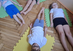 Zdjęcie przedstwia czworo dzieci z grupy IV w pozycji leżenie tyłem.