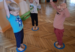 Zdjęcie przedstawaia dzieci z grupy I podczas wykonywania ćwiczeń z krążkami.