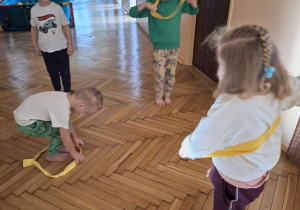 Zdjęcie przedstawaia dzieci z grupy II podczas wykonywania ćwiczeń z szarfami.